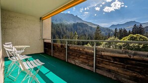 Un balcón con vistas a un bosque y montañas.