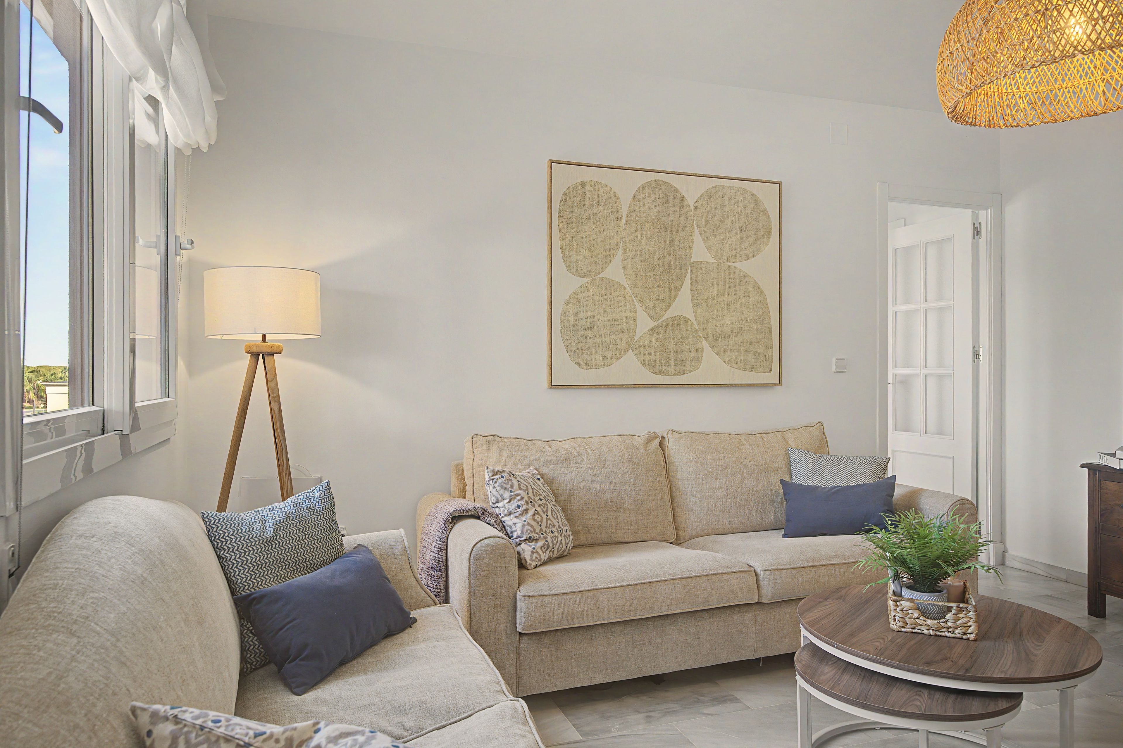 A living room with a sofa, a floor lamp, a coffee table, and a wall art piece.