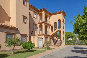 Un edificio de varios pisos con fachada simétrica, balcones y una escalera central.