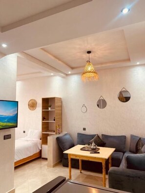 Una sala de estar moderna con un sofá, una mesa de centro y una televisión.