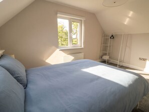 A bedroom with a bed, a window, a radiator, and a white metal shelf. - 30 RIVER RUN, family friendly in Belturbet, County Cavan (Belturbet)
