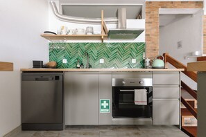 Una cocina compacta con lavavajillas, horno y salpicadero con diseño de espiga.