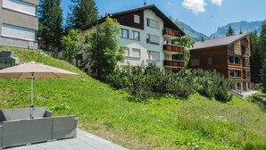 A multi-story building with balconies, surrounded by greenery and mountains. - Fürggli Appartement/Fewo, Dusche und Bad, WC, Erdgeschoß/Parterre by Interhome (Arosa)