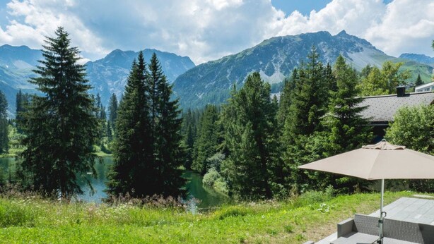 A patio with outdoor furniture and a view of a lake and mountains. - Fürggli Appartement/Fewo, Dusche und Bad, WC, Erdgeschoß/Parterre by Interhome (Arosa)