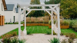 A white pergola structure in a garden with a lawn and trees in the background. - Large Holiday Home, Jacuzzi, Sauna (Choczewo)