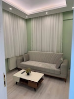 Una sala de estar con un sofá, una mesita de centro y una planta en maceta.