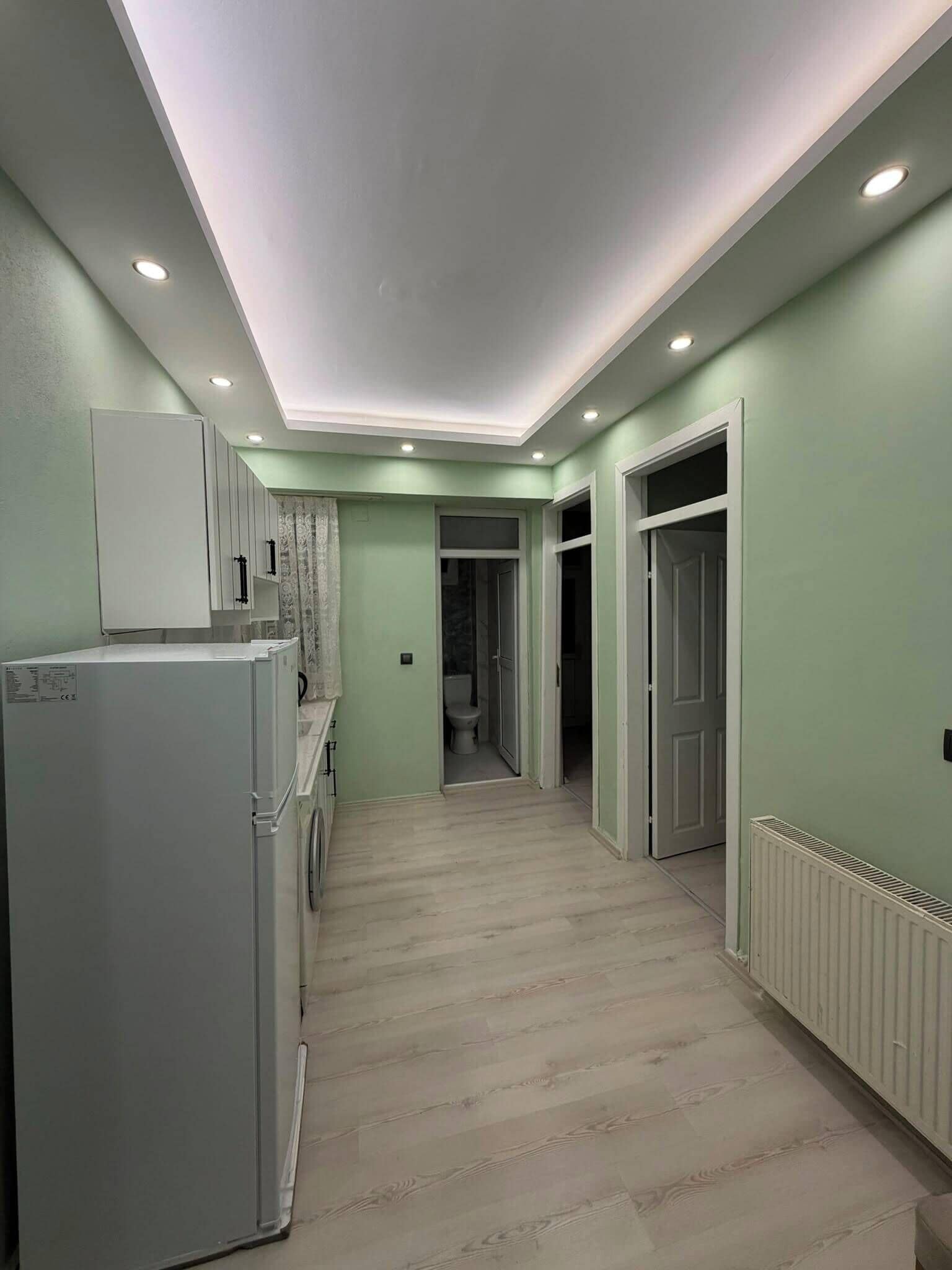 A laundry room with a washing machine, a dryer, and a radiator.