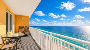 Ein Balkon mit Tisch, Stühlen und einer Karaffe Getränke.