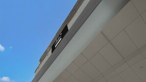 A building with a clear sky, a sign reading 'Café Ristorante,' and a tiled ceiling. - Premium Budha Tower (Noida)