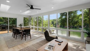 Ein modernes Wohnzimmer mit Essbereich, großen Fenstern und Seeblick.