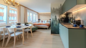 Une chambre moderne comprenant un coin repas, un lit et une kitchenette.