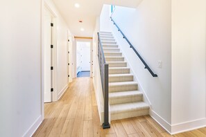 Ein modernes Interieur mit Holzboden, Teppichstufen und weißen Wänden.
