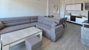 Una sala de estar moderna con un sofá modular, una mesa de centro y un comedor con sillas.
