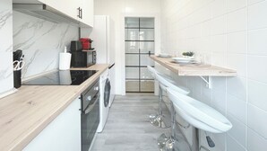 A modern kitchen with a wooden countertop, built-in oven, and a stainless steel refrigerator. - NA&DIA HOME by wehomes (Santander)