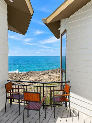 Ein Balkon mit Blick auf den Ozean und einen Sandstrand.
