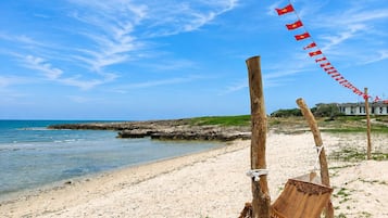 Ein Strand mit einer Hängematte und einer Reihe von Flaggen.