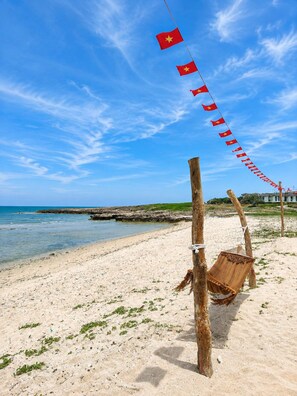 Une plage avec un hamac et une rangée de drapeaux.