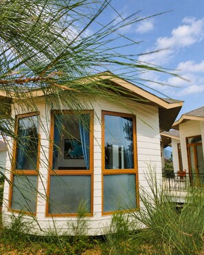 Ein Haus mit großen Fenstern, einem geneigten Dach und einem sichtbaren Außenbereich.