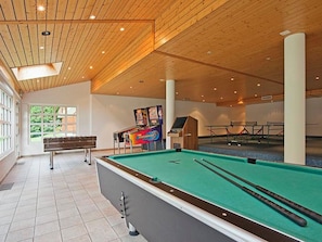 A pool table with cues, a foosball table, and a dartboard in a room with wooden ceilings and large windows. - Les Naturelles B 306 # 6-bed apartment, Dusche und Bad, WC by Interhome (Leukerbad)