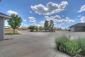 A residential driveway with a garage, a covered patio, and a landscaped area with trees and shrubs. - New Listing! Golf Course & Mtn Views | A/C | Spacious Townhome (Pagosa Springs)