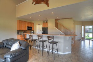 A modern kitchen with a bar area, a leather sofa, and a staircase leading to another level. - New Listing! Golf Course & Mtn Views | A/C | Spacious Townhome (Pagosa Springs)