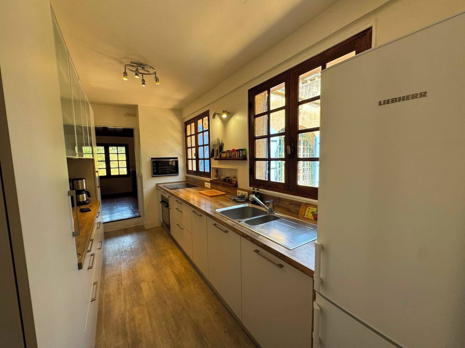 Una cucina con forno integrato, microonde, lavello e frigorifero.