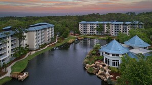 Un resort con diversi edifici, una vasca d'acqua centrale e vegetazione circostante.