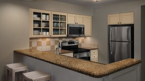 A kitchen with a granite countertop, stainless steel appliances, and light-colored cabinetry. - Ocean Vists unit.  Resort with 2 bedrooms and AC in tranquil Hilton Head Island (Hilton Head Island)