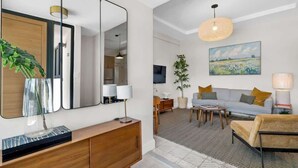 Una sala de estar moderna con un sofá, una mesa de centro y un espejo grande.