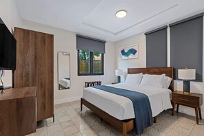 Ein Hotelzimmer mit Bett, Nachttischen, einem Spiegel, einem Fenster und einem Wandbild.