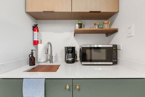 Eine Küche mit Mikrowelle, Kaffeemaschine und Feuerlöscher.