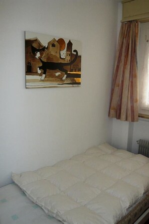 A room with a bed, a painting on the wall, and a window with curtains. - Gitzifurka 4 # 4-bed apartment, Dusche, WC 4-Bettwohnung, Dusche, WC by Interhome (Leukerbad)