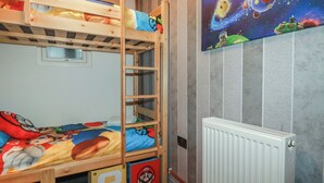 Kerrossänky, jossa on tikkaat, ikkuna ja seinä, jossa on avaruusteemainen juliste.