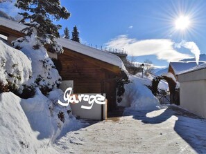 A snowy outdoor area with a wooden building, a garage sign, and a clear sky. - Abendstern 2 # 2-bed apartment, Dusche, WC 2-Bettwohnung, Dusche, WC by Interhome (Albinen)