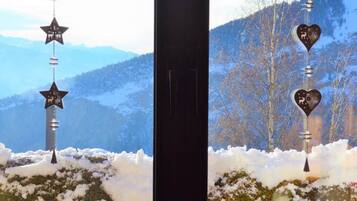 A window with a view of snow-covered hills and a clear sky.