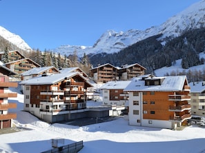 A snow-covered mountain resort with wooden buildings and balconies, surrounded by snow-covered trees and mountains. - Europe 16 # 4-bed apartment, Bad, WC 4-bed apartment, Bad, WC by Interhome (Leukerbad)