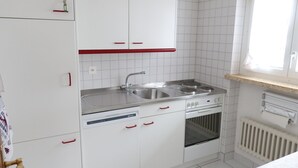 A kitchen with white cabinets, a stainless steel sink, a stove, and an oven. - Europe 16 # 4-bed apartment, Bad, WC 4-bed apartment, Bad, WC by Interhome (Leukerbad)