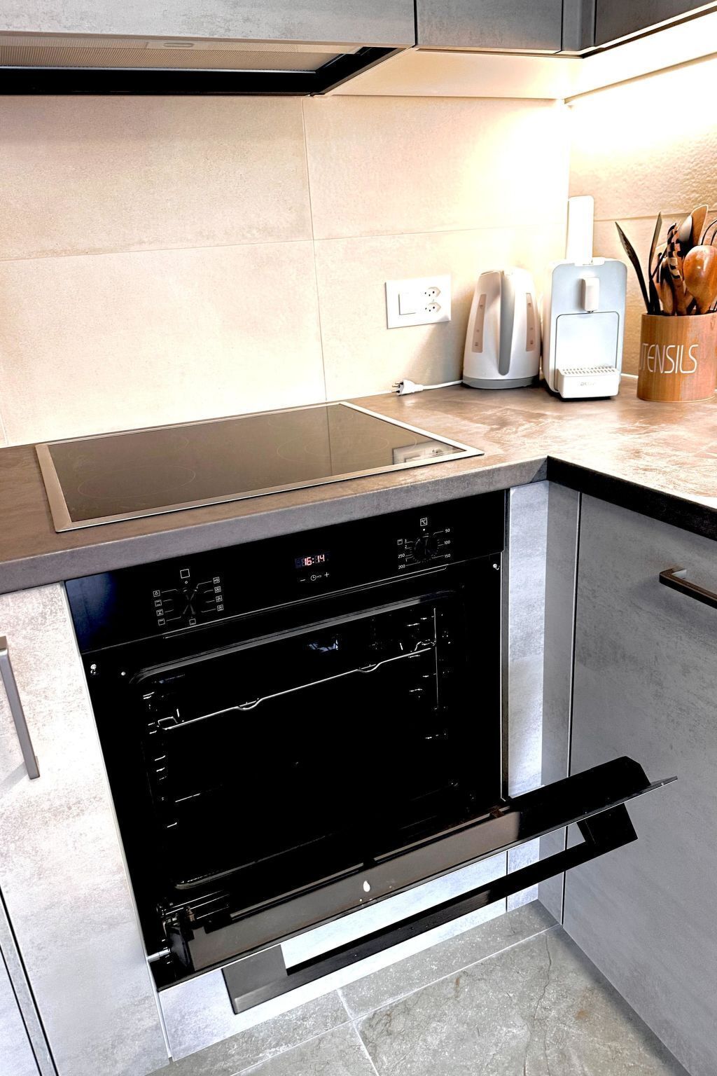 A kitchen with a built-in oven, a stovetop, and a coffee maker on the counter.