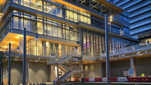 Un immeuble à plusieurs étages doté de façades en verre et d’escaliers extérieurs.