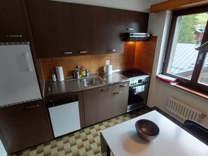 A compact kitchen with a dishwasher, stove, and sink. - Floralp 5 # 4-bed apartment, Bad, WC 4-Bettwohnung, Bad, WC by Interhome (Leukerbad)