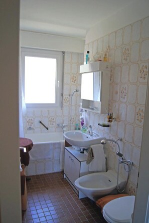 A bathroom with a bathtub, sink, and toilet. - Mayenzett 41 # 4-bed apartment, Bad, WC 4-Bettwohnung, Bad, WC by Interhome (Leukerbad)