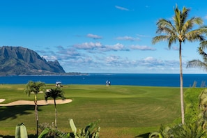 Ein Golfplatz mit Blick auf das Meer und die Berge.