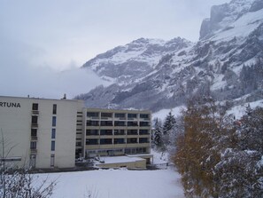 A building with 'FORTUNA' signage, surrounded by snow-covered mountains. - Fortuna 202 # 4-bed apartment, Dusche, WC 4-Bettwohnung, Dusche, WC by Interhome (Leukerbad)