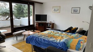 Una camera da letto con un letto, una televisione, una scrivania e una sedia.