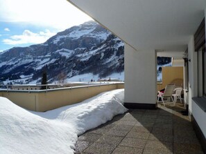 A balcony with a snow-covered ground, a mountain view, and a chair. - Royal 50 # 4-bed apartment, Dusche, WC 4-Bettwohnung, Dusche, WC by Interhome (Leukerbad)
