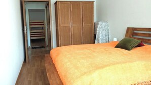 Ein Schlafzimmer mit einem Bett, einem Holzschrank und einer Tür zum Badezimmer.