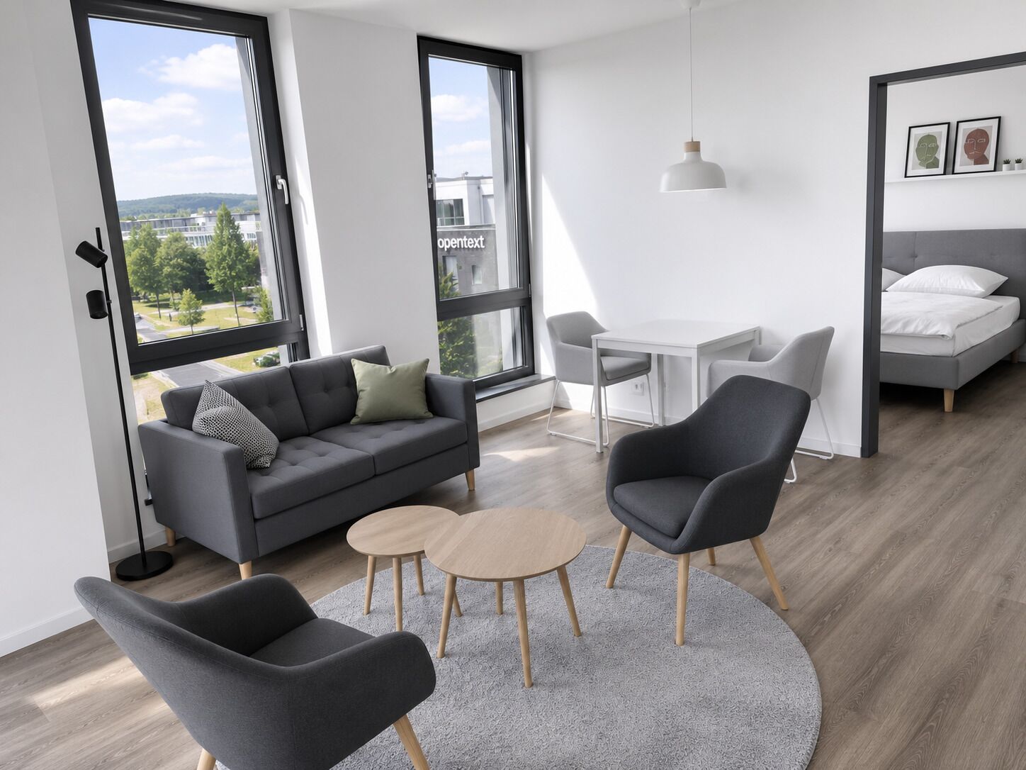 En moderne stue med sofa, to stole, et lille bord og en seng.