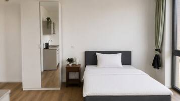 Ein Schlafzimmer mit einem Bett, Nachttisch und Blick ins Freie.
