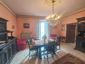 Un comedor con una mesa, sillas, una araña y un radiador.