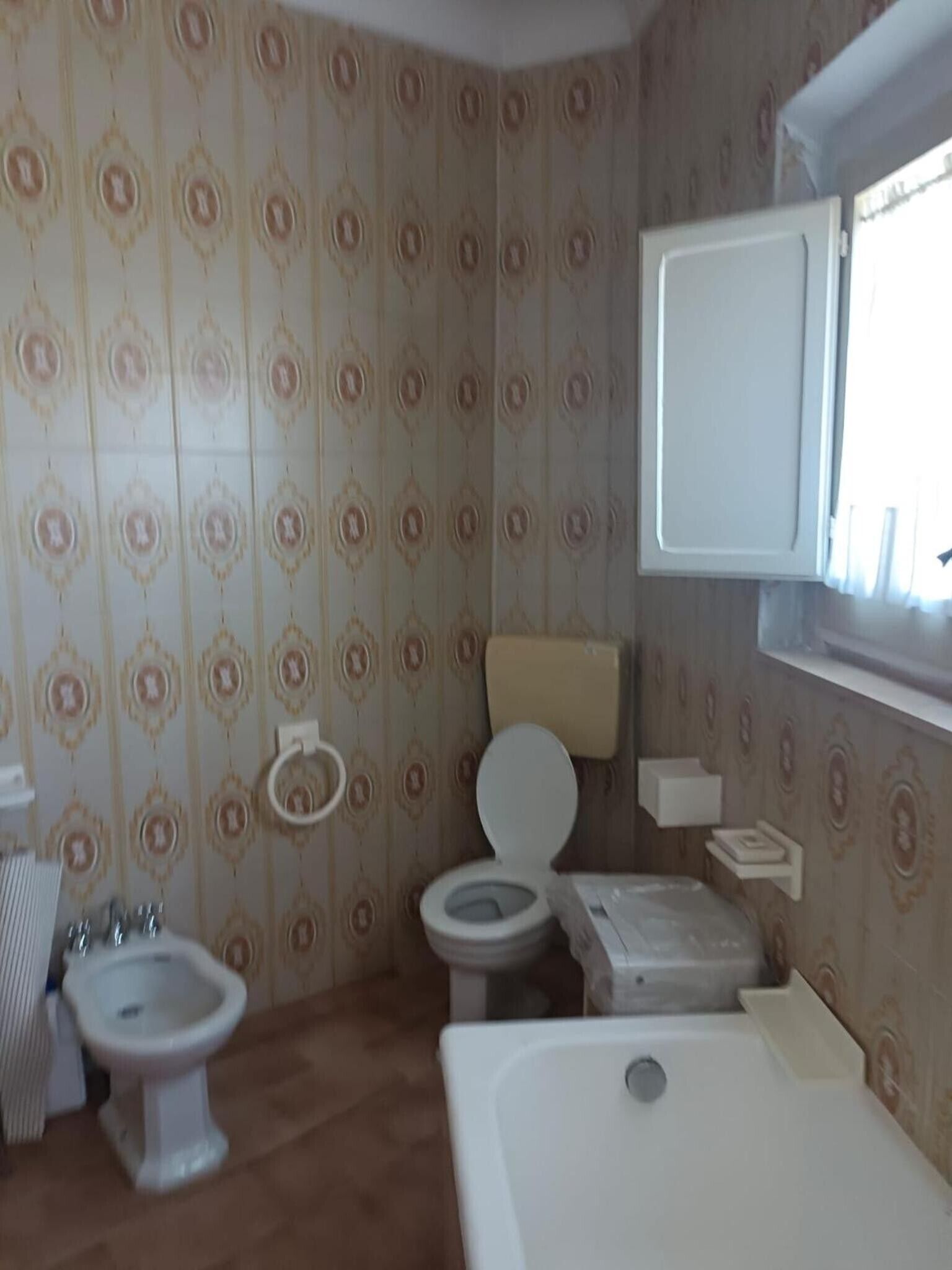 A bathroom with a toilet, bidet, and bathtub.